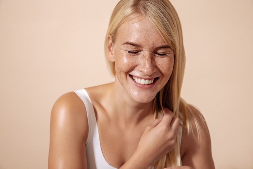 A person smiling with freckles.